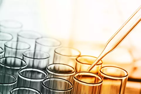 Reihen von Reagenzgläsern mit Pipette